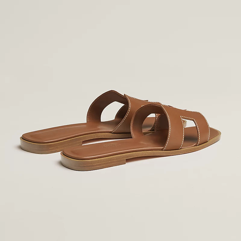 Oran sandal tan leather slide with open toe and crossover straps, flat sole