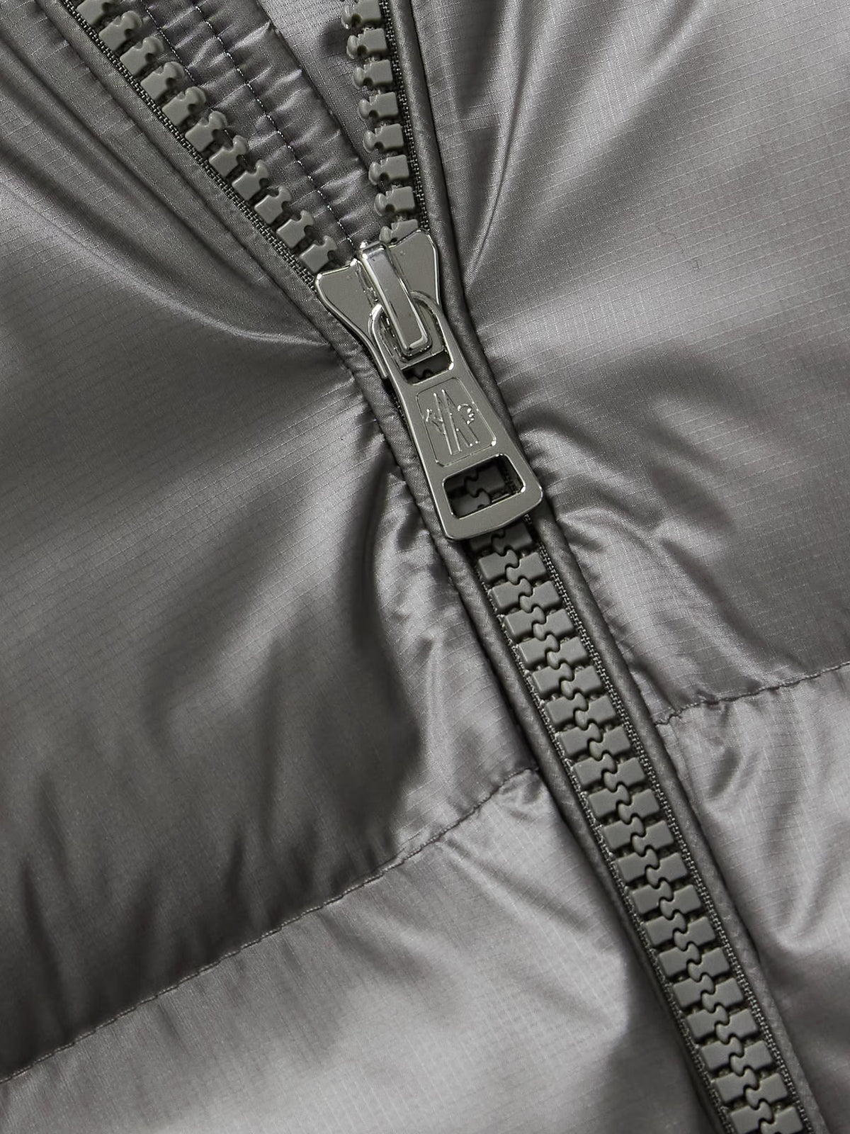 Gray jacket close-up: metal zipper and stitched seam details