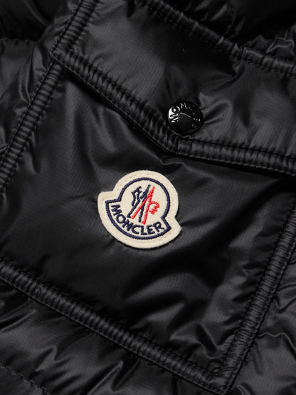 Black down jacket fabric close-up with MONCLER patch