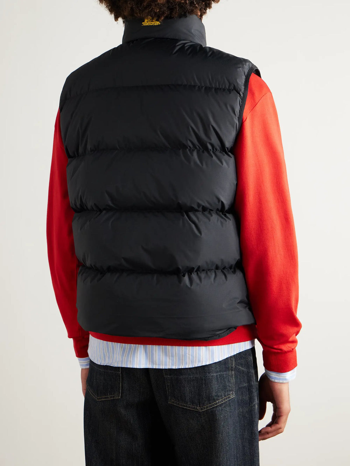Back view: black quilted sleeveless vest with padded horizontal baffles